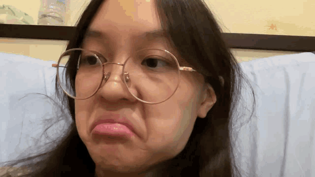 a woman wearing glasses is making a face