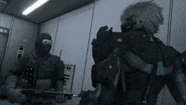 a man in a black mask holds a gun next to another man