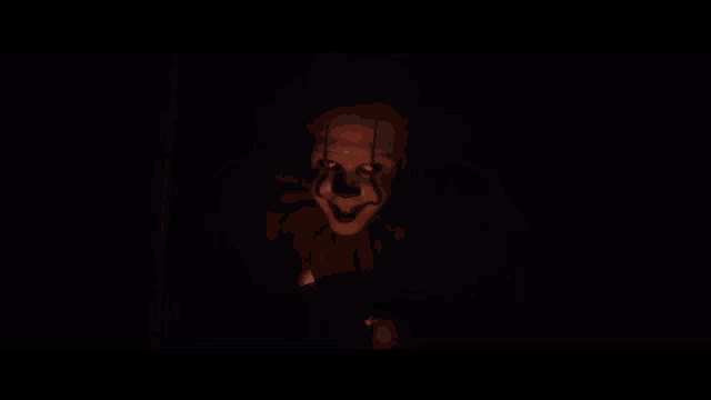 a creepy clown with blood on his face is looking at the camera