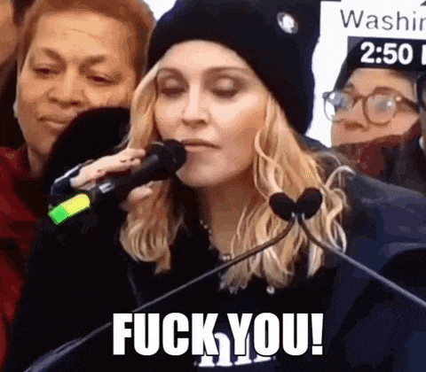 a woman is holding a microphone and saying `` fuck you '' .