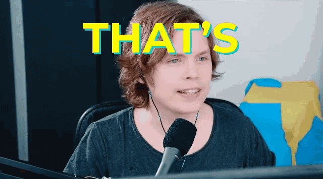 a man with a microphone in front of a screen that says that 's on it