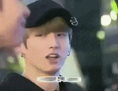 a close up of a person wearing a hat and earrings .
