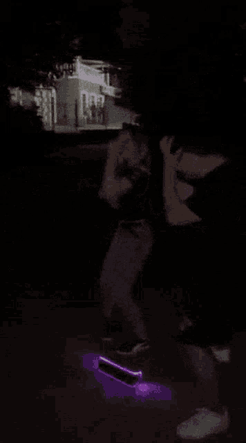 a person riding a skateboard in the dark with a light on it