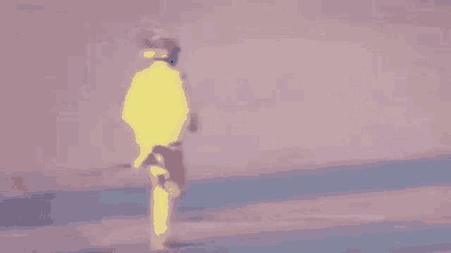 a person in a yellow suit is walking on a pink and blue surface .