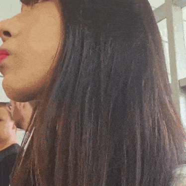 a close up of a woman 's face with long hair and red lipstick