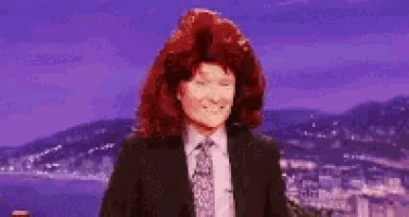 a woman with red hair in a suit and tie