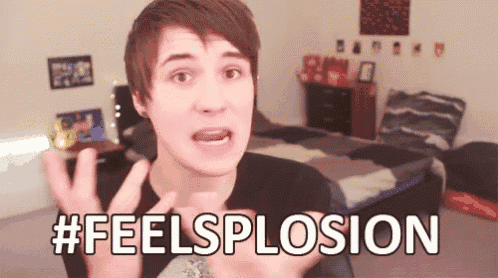 a young man is making a funny face and says #feelsplosion in front of a bed .