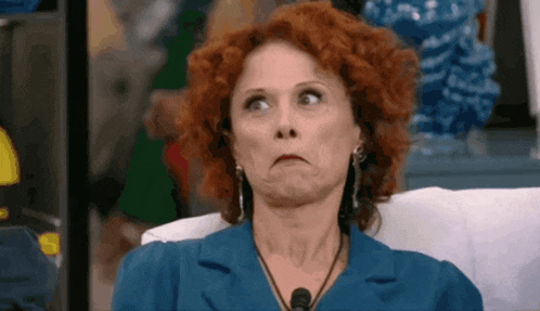 a woman with red hair is making a face while sitting on a couch