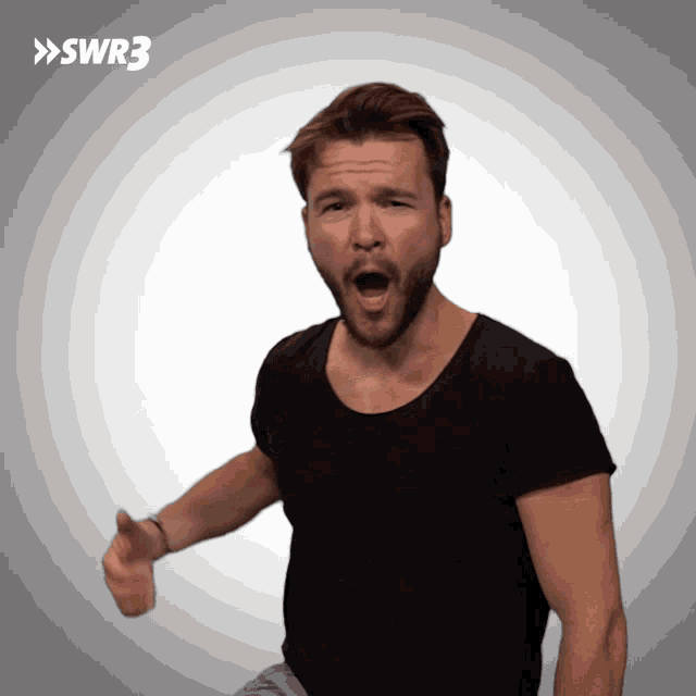 a man in a black shirt is making a funny face with swr3 in the background