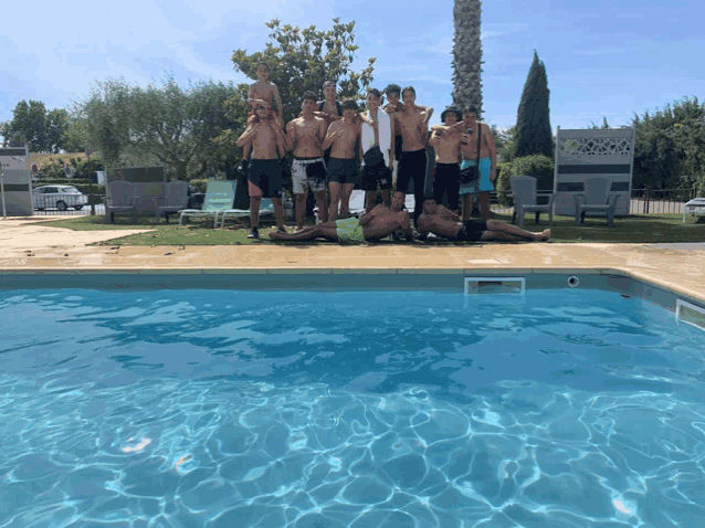 a group of people posing for a picture in front of a pool