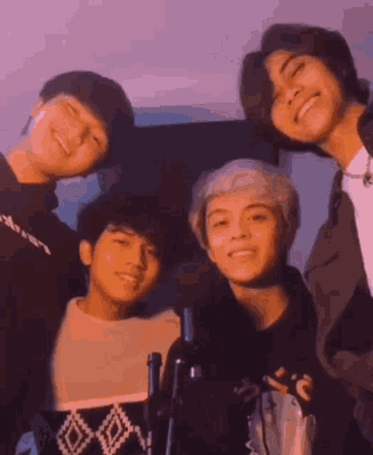a group of young men are posing for a picture while standing next to each other .