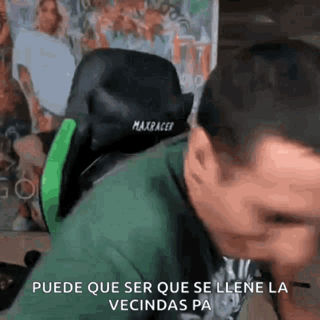 a man in a green shirt is sitting in a green and black gaming chair .