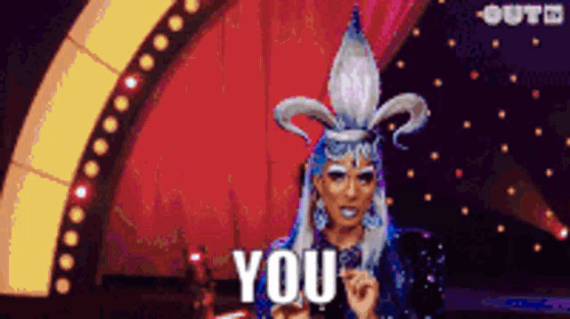 a drag queen says you in front of a stage