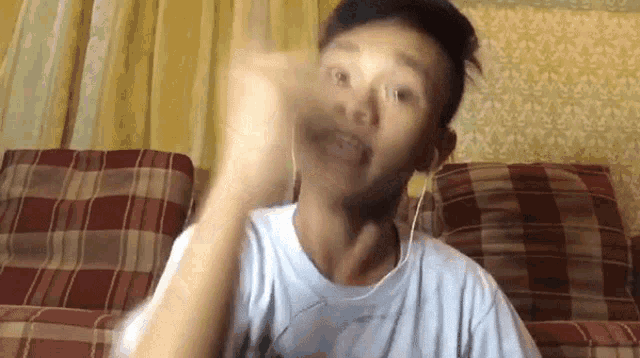 a man wearing ear buds is sitting on a couch