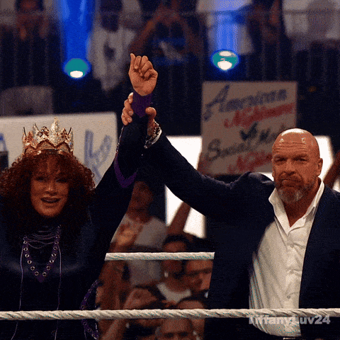 a man and a woman in a wrestling ring with a sign that says american nightmare behind them
