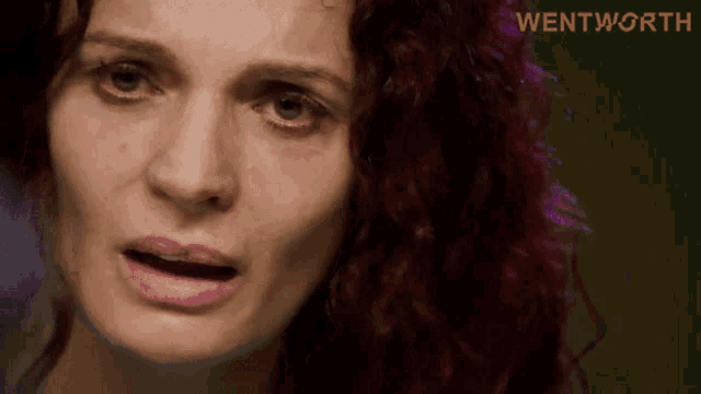 a close up of a woman 's face with the word wentworth in yellow