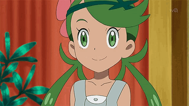 a close up of a cartoon character with green hair and a pink flower in her hair .