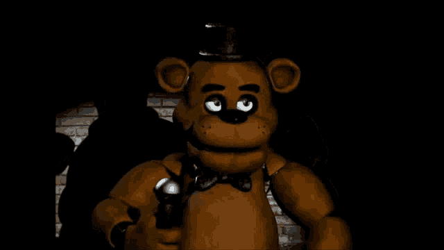 a brown teddy bear with a top hat and bow tie is holding a microphone