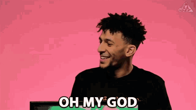 a man is laughing and saying oh my god in front of a tv .