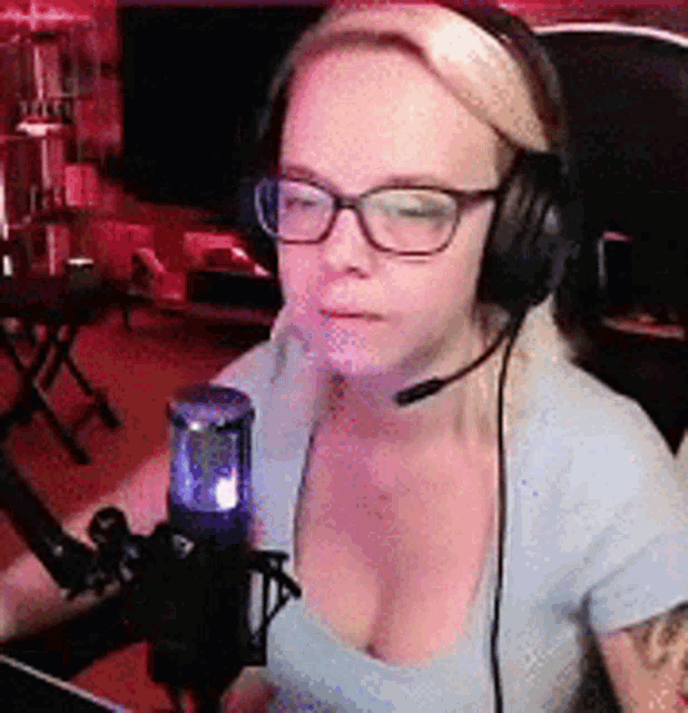 a woman wearing headphones and glasses is talking into a microphone .