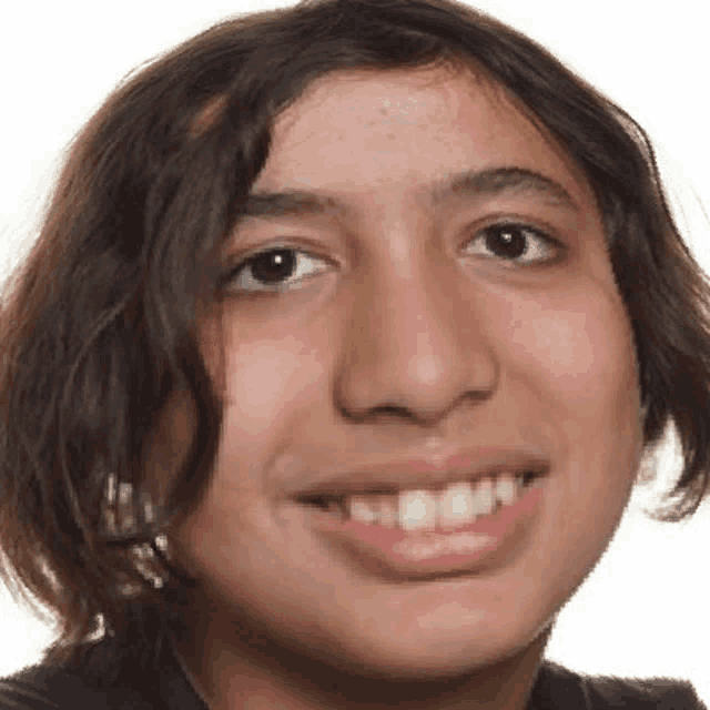 a young boy with long hair is smiling for the camera