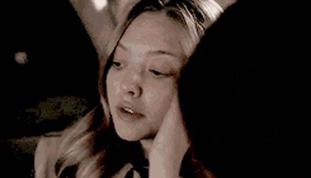 a woman is touching her face with her hand