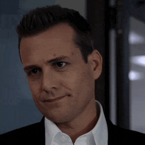a close up of a man 's face with a black suit and white shirt