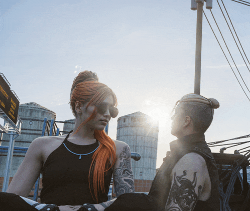 a woman with red hair stands next to a man with a tattoo on his shoulder