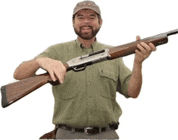 a man with a beard is holding a shotgun in his hands