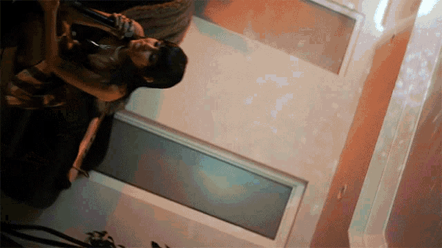 a woman is holding a bottle in her hand in a room