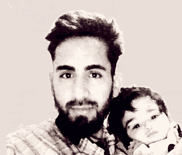 a man with a beard holds a small child in his arms