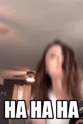 a woman is laughing in a room with the words ha ha ha written on her face