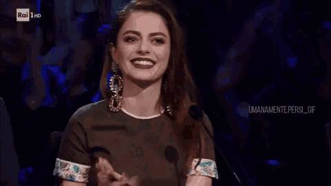 a woman is clapping in front of a rai 1 hd sign