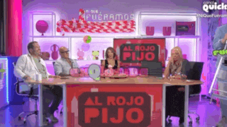 a group of people are sitting around a table with a sign that says al rojo pijo