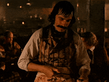 a man is cutting a piece of meat with a large knife