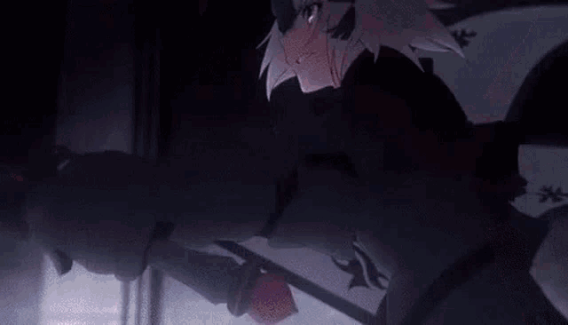 a close up of a person holding a sword in a dark room with a red light coming out of their hand .