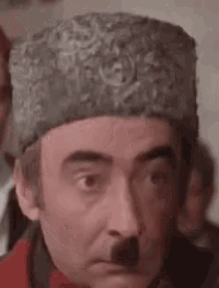 a man wearing a hat with a mustache on his face .