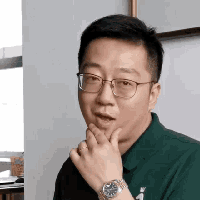 a man wearing glasses and a watch has a ring on his left hand