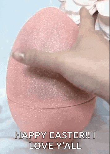 a person is holding a pink easter egg with the words `` happy easter ! i love y ' all '' on it .