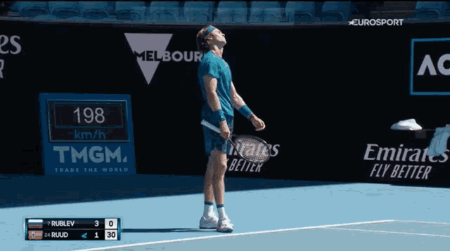 a tennis player stands on a court with ads for emirates and tmgm in the background