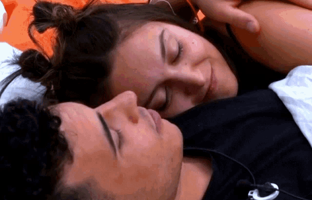 a man and a woman are laying next to each other