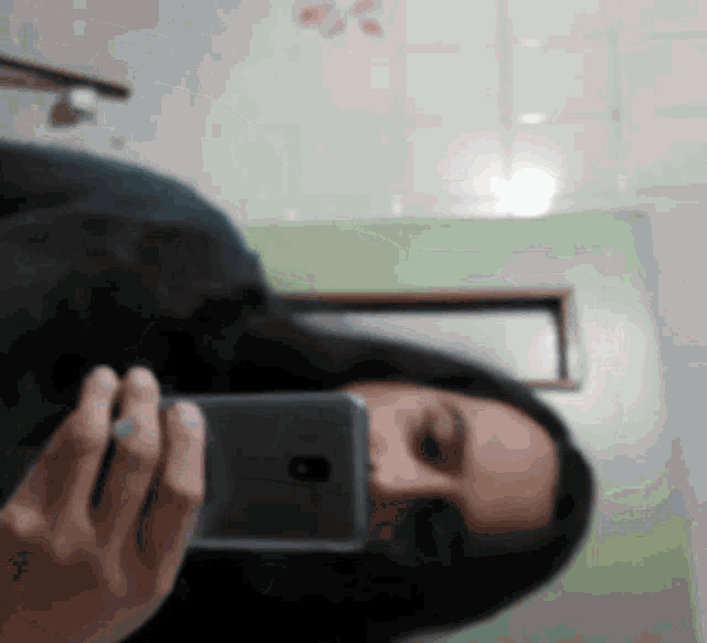 a woman is taking a picture of herself with her cell phone