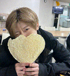 a person is holding a heart shaped object in front of their face