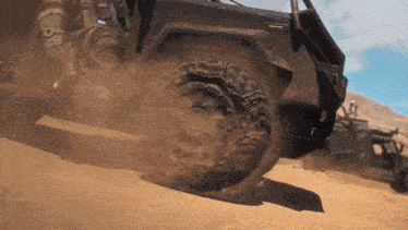 a jeep is driving down a dirt road and the tires are covered in dirt