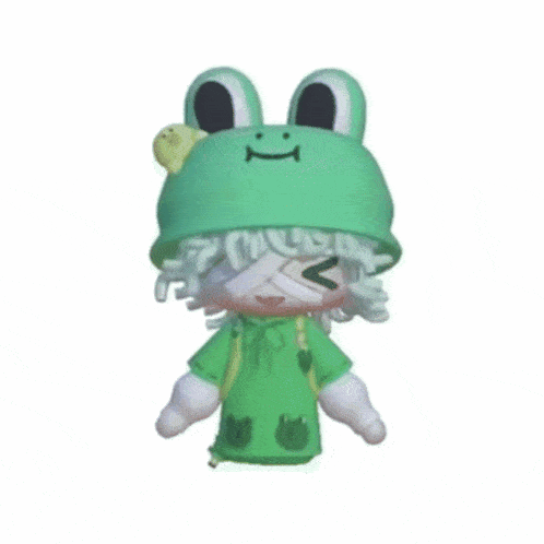 a doll wearing a green frog hat and a green shirt with frogs on it