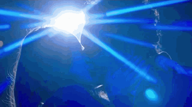a person in a dark room with blue lights shining on them
