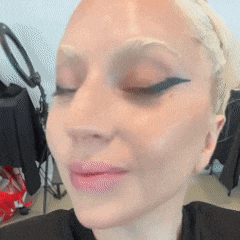 a close up of a woman 's face with her eyes closed and a ring light in the background