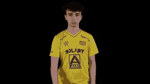 a young man wearing a yellow shirt with a aldi logo on it .