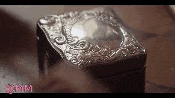 a silver box sits on a wooden table with the hashtag @mm on the bottom