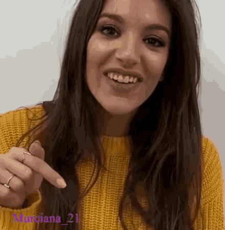 a woman wearing a yellow sweater with the name murciana 21 on the bottom